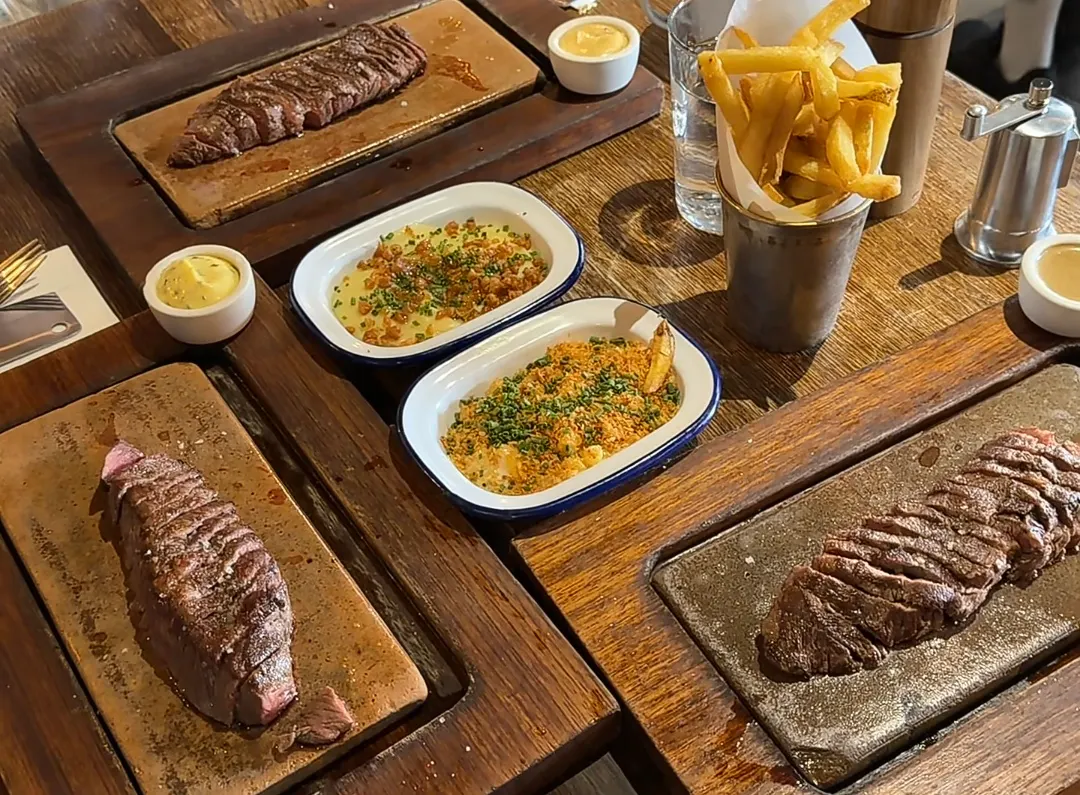 A full table of Flat Iron steaks, beef-dripping chips and sides