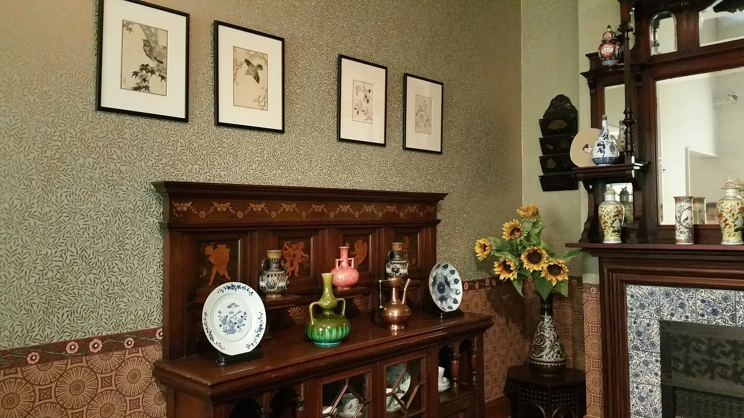 A 19th-century-style home interior at the Museum of the Home, with a wooden dresser, vases and a fireplace