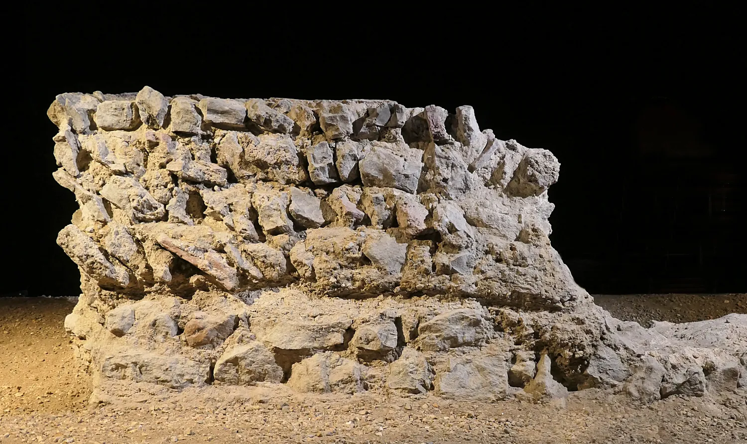 Remains of the Roman amphitheatre underground: a stretch of stone wall foundation